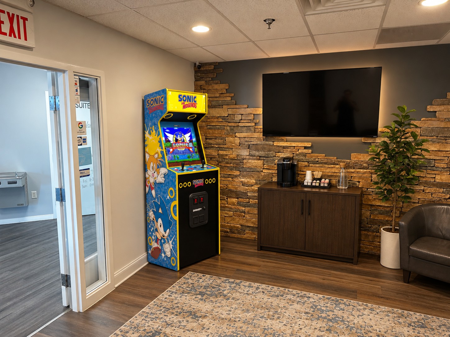 Coffee cabinet, TV and Sonic arcade machine near the entrance