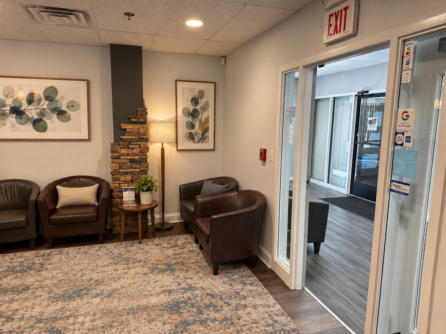 Waiting-room armchairs and artwork beside the office entrance
